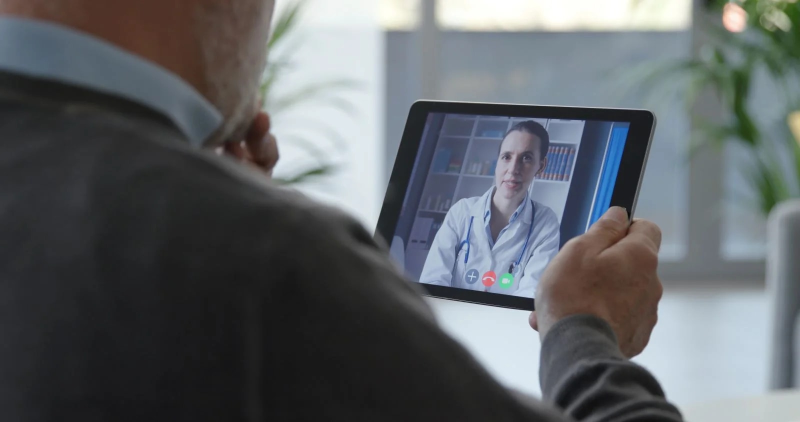 Paciente em consulta psiquiátrica por telemedicina diante de notebook em ambiente doméstico