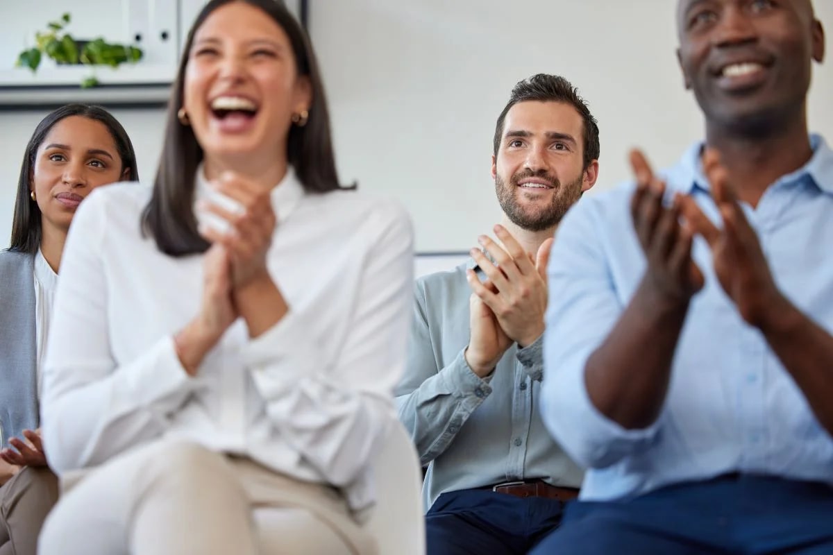 Profissional palestrando sobre saúde mental corporativa para plateia atenta em evento empresarial