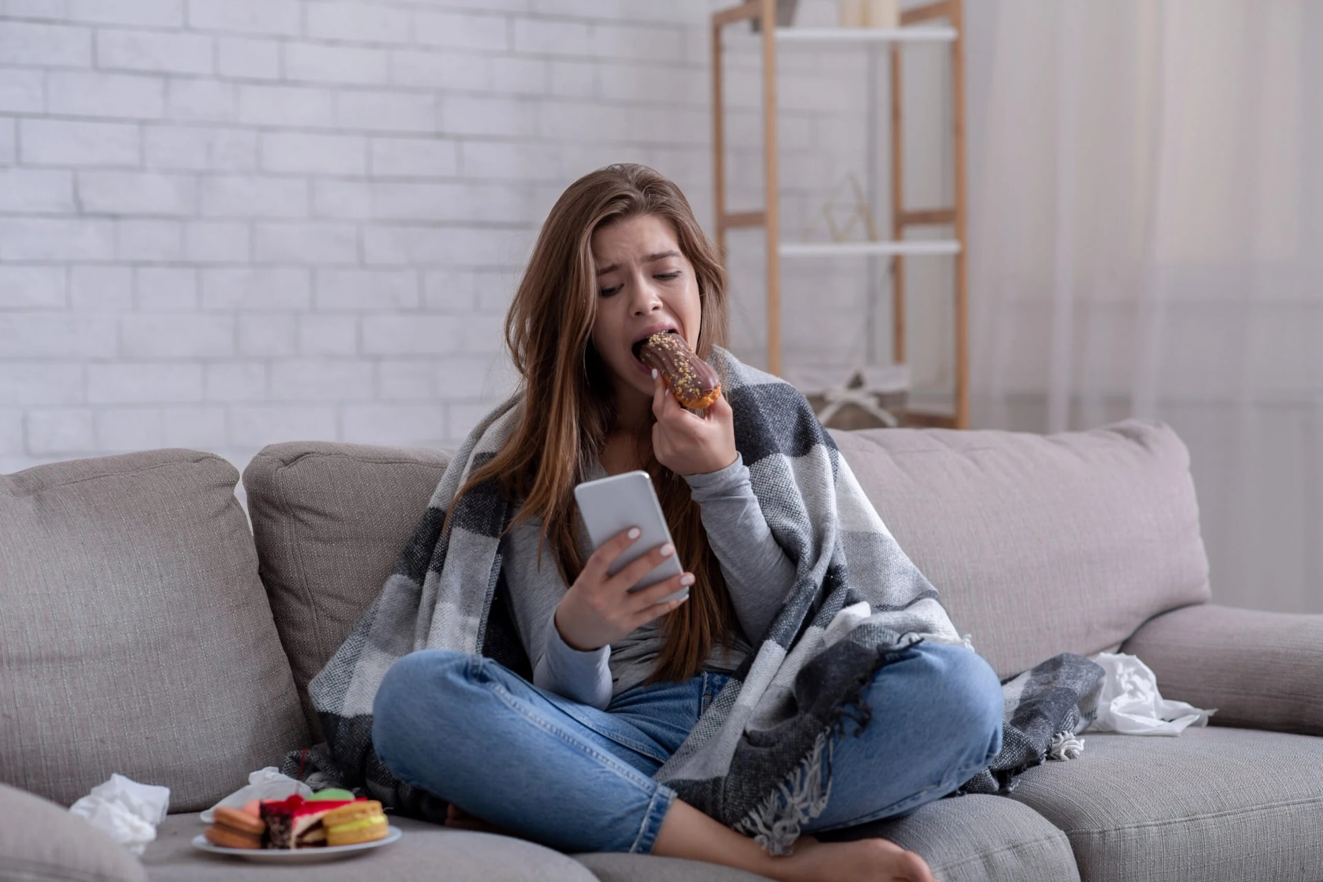 Mulher comendo doce em momento de fome emocional como fuga das emoções difíceis