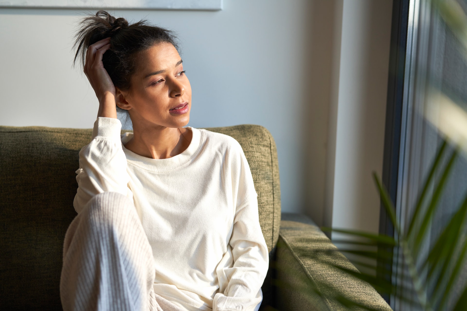 Mulher em postura relaxada em casa, com roupa confortável. Imagem editorial sobre ansiedade no Instituto Alceu Giraldi.